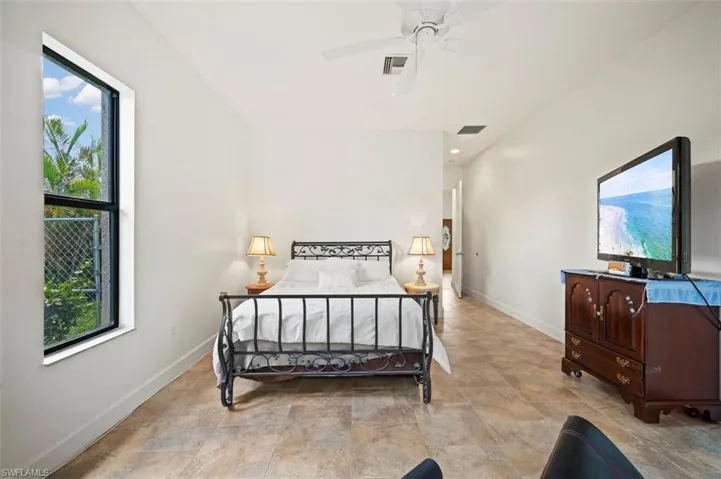 Bedroom with stone finish floors and a ceiling fan