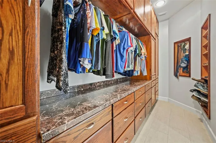 Walk in closet with light tile patterned flooring