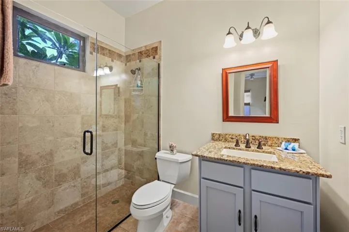 Bathroom with vanity, a stall shower, and tile patterned flooring
