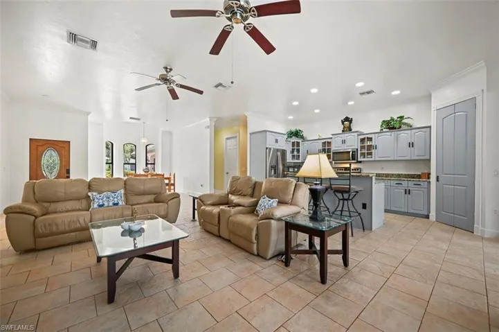 Living area featuring ceiling fan, recessed lighting, and crown molding