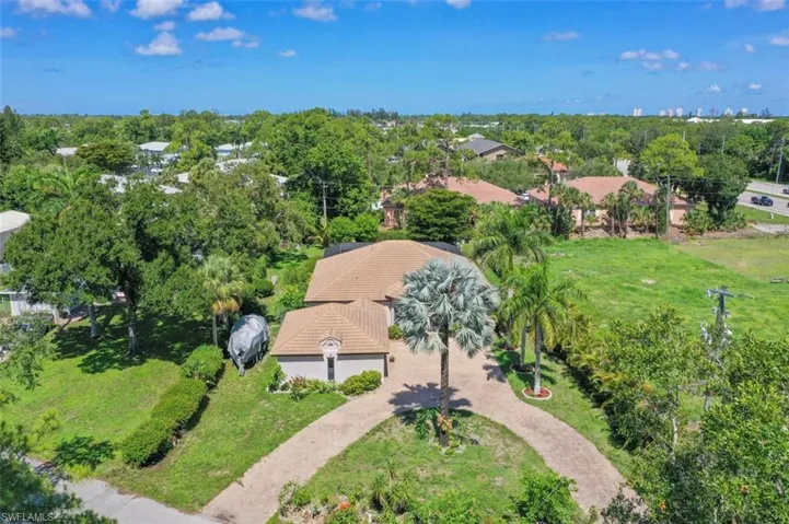 Aerial view of property and surrounding area with a tree filled landscape