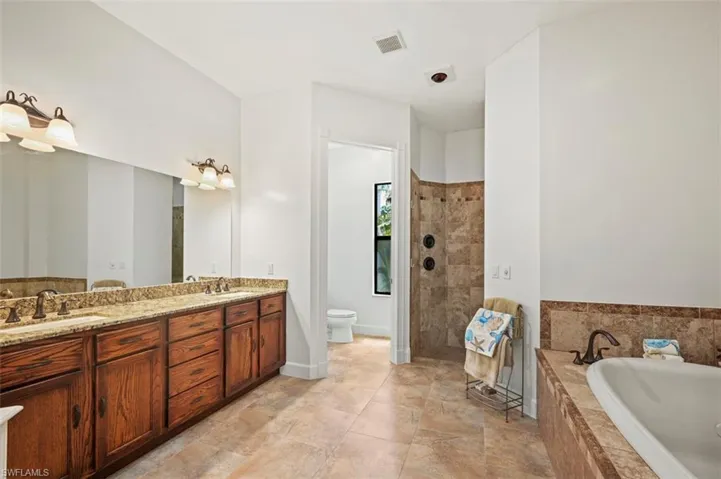 Bathroom featuring a garden tub, double vanity, and a walk in shower