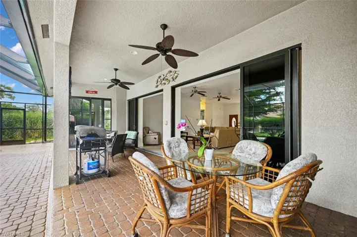 View of patio / terrace featuring outdoor dining area, a lanai, a ceiling fan, and area for grilling