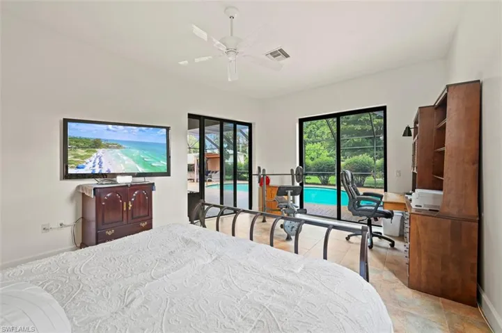 Bedroom with access to exterior, an office area, and ceiling fan