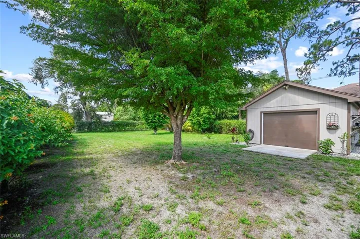 View of green lawn featuring a garage