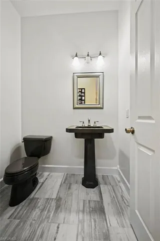 Bathroom featuring baseboards and toilet