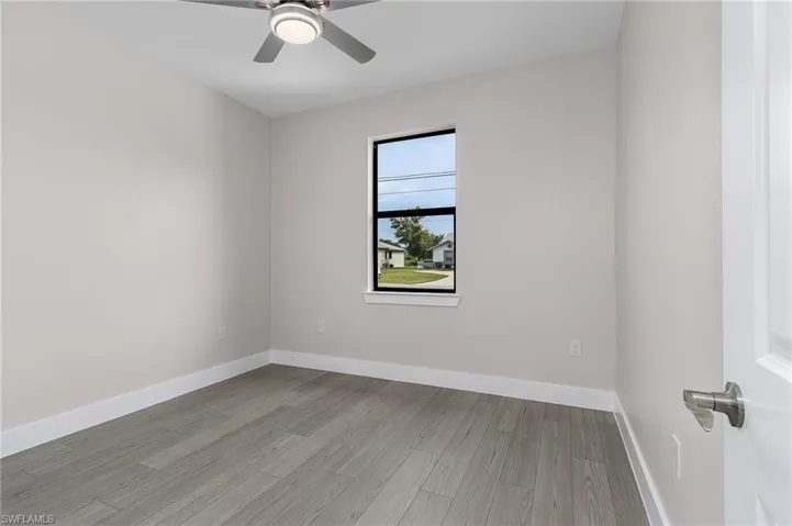 Empty room with light wood finished floors and a ceiling fan