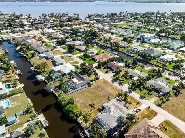 Aerial view of property and surrounding area with nearby suburban area and a nearby body of water