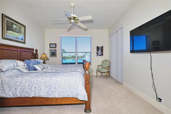 Carpeted bedroom featuring a ceiling fan and baseboards
