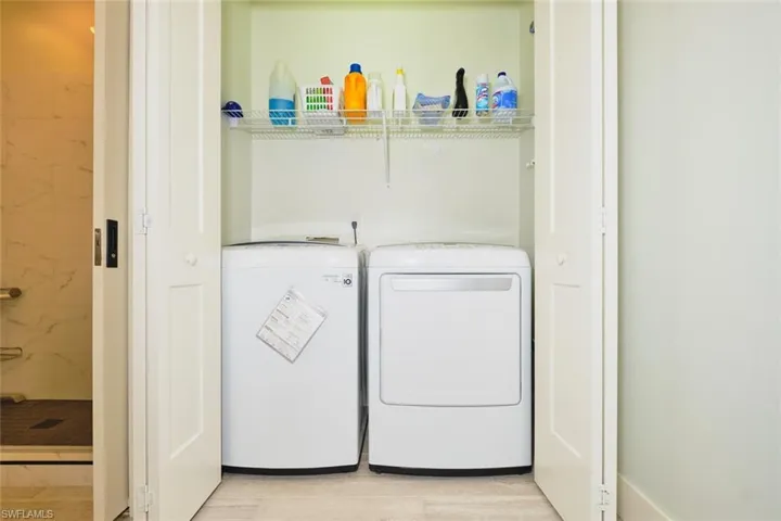 Laundry room with washer and dryer and light wood-style flooring