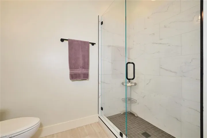 Full bathroom with baseboards and a marble finish shower
