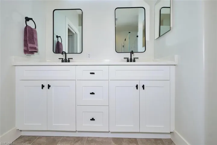 Bathroom featuring baseboards and double vanity