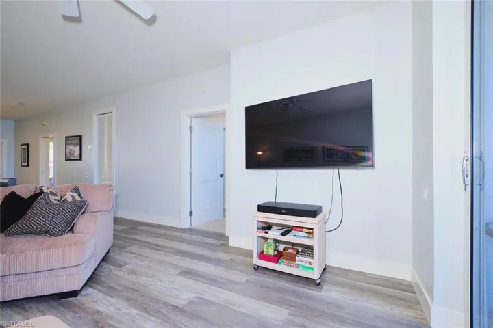 Living room with ceiling fan and light wood-type flooring