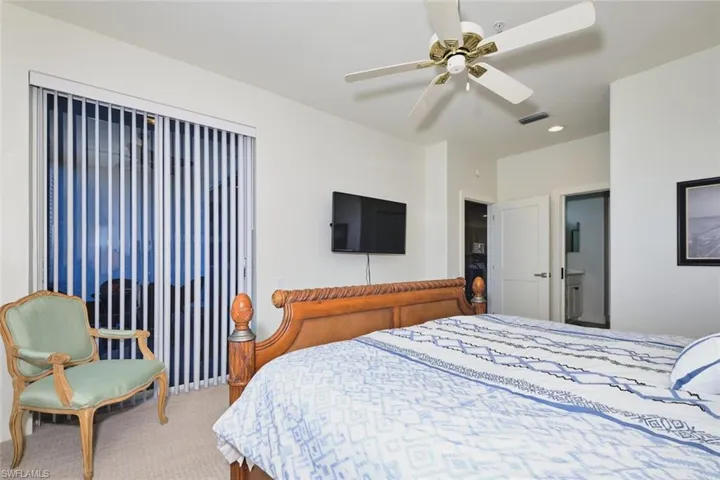 Bedroom featuring carpet flooring, a ceiling fan, and ensuite bathroom