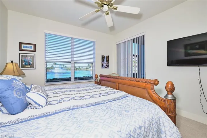 Carpeted bedroom featuring a ceiling fan and baseboards