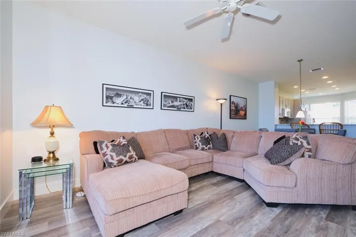Living room with wood finished floors, recessed lighting, and a ceiling fan