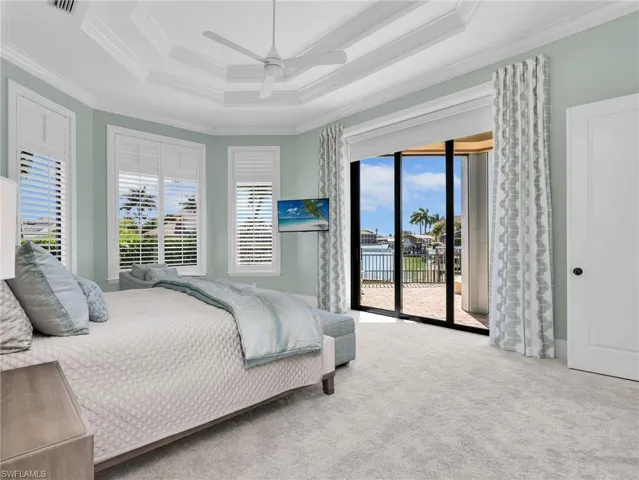 Carpeted bedroom featuring access to outside, a ceiling fan, and ornamental molding