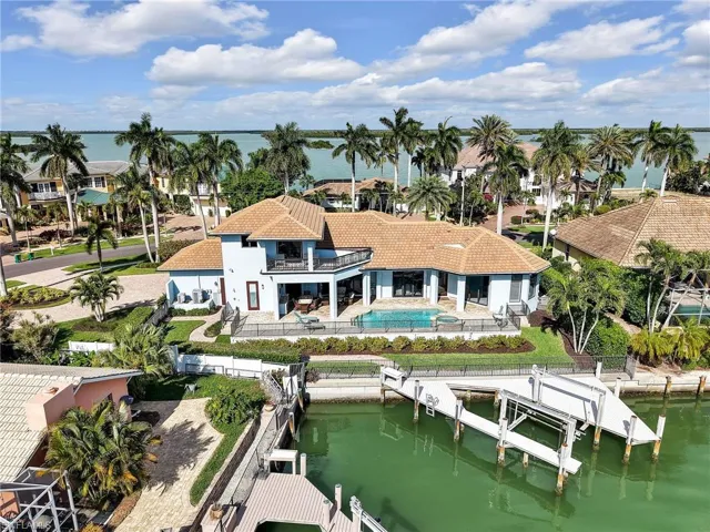 Bird's eye view of a nearby body of water and a pool area