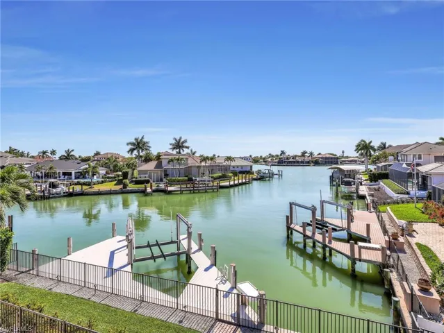 Dock area with boat lift, a residential view, and a water view