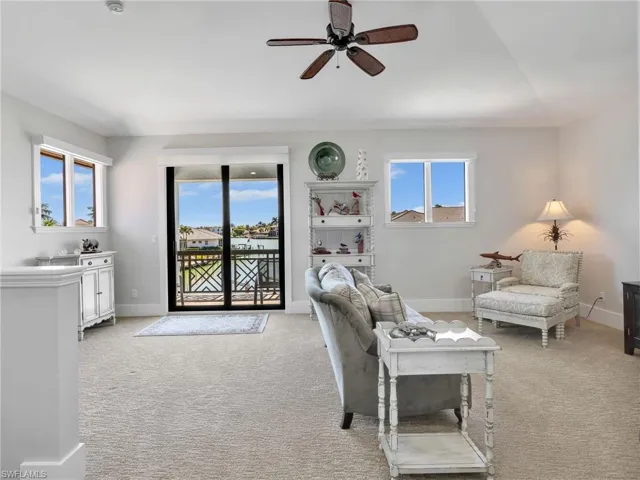 Living area featuring light carpet and a ceiling fan
