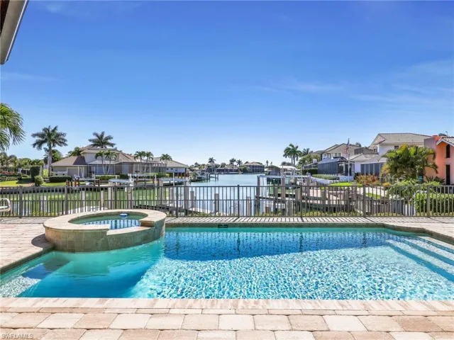 Integrated pool / spa with a residential view, a patio, and a water view