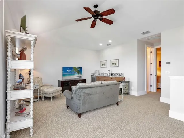 Living room with a ceiling fan, light colored carpet, and recessed lighting
