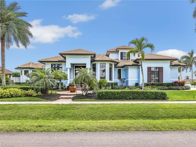 Mediterranean / spanish home featuring stucco siding, a tiled roof, and a front lawn