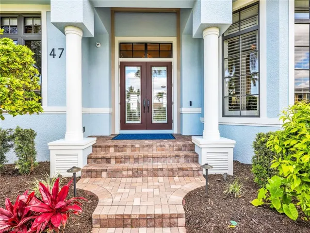 Property entrance with french doors, stucco siding, and a porch