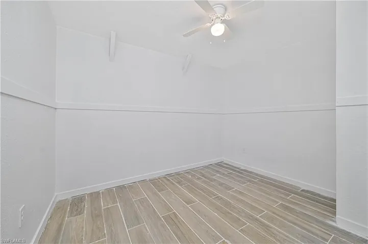 Unfurnished room featuring wood tiled floors and a ceiling fan