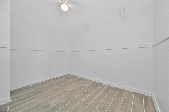 Spare room featuring wood tiled floors and baseboards