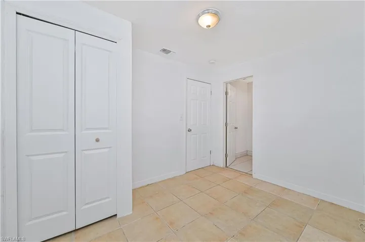 Unfurnished bedroom featuring a closet and light tile patterned floors