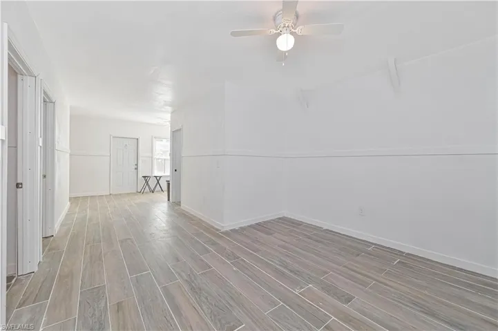 Empty room with wood tiled floors and ceiling fan