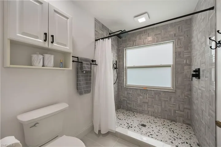 Full bathroom with a shower stall and light tile patterned floors