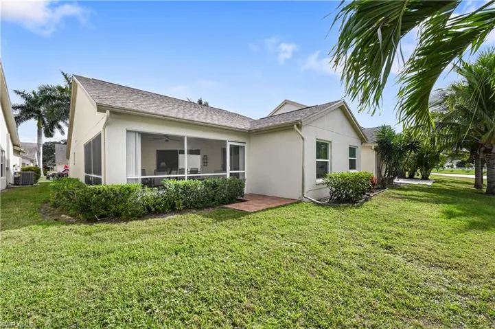Back of property featuring stucco siding, a lawn, ceiling fan, a sunroom, and a shingled roof