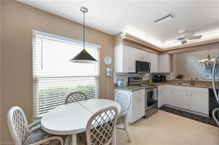 Kitchen featuring pendant lighting, stainless steel appliances, and white cabinets