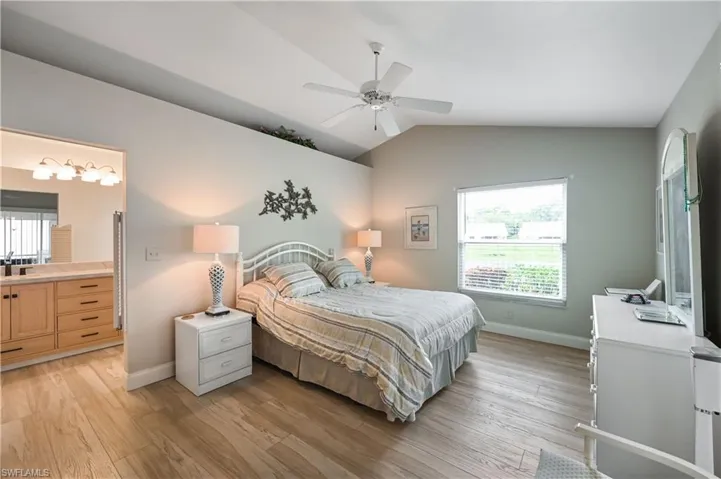 Bedroom with lofted ceiling, light wood-style flooring, and a ceiling fan