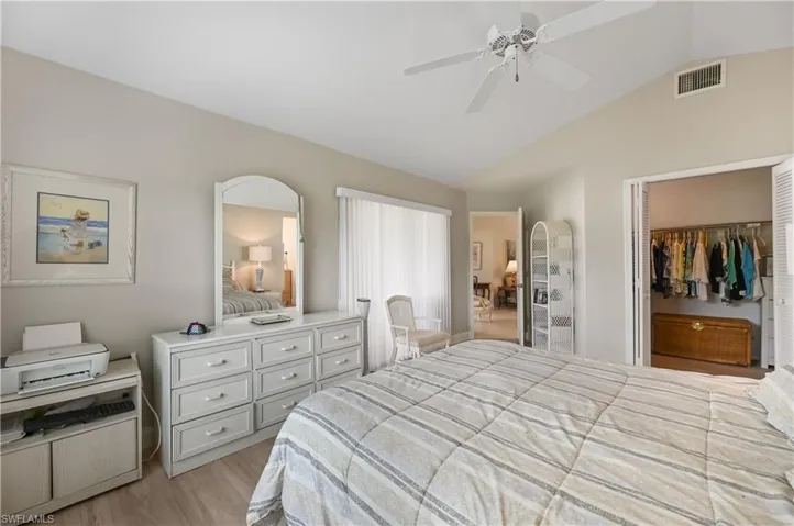 Bedroom featuring vaulted ceiling, a closet, a ceiling fan, and light wood finished floors