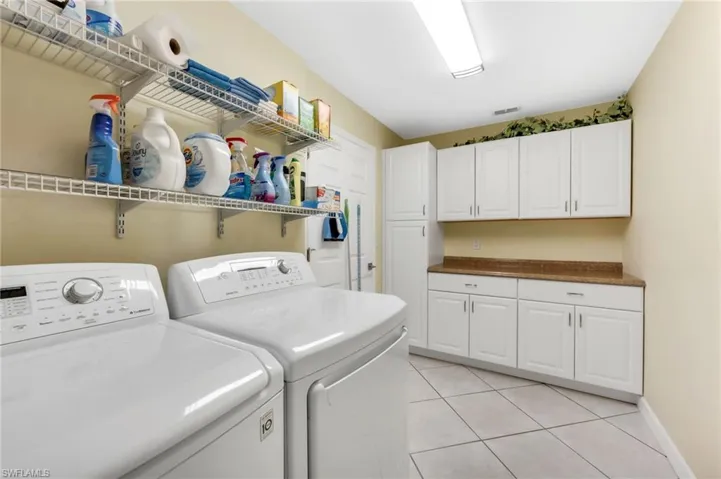 Large laundry space featuring cabinetry and a utility sink.
