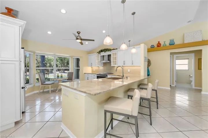 This well-appointed kitchen features plenty of counter space, ample cabinetry, and a dining space.