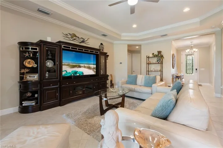 Tray ceiling with recessed lighting, ceiling fan, and crown molding