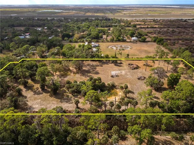 Aerial view of sparsely populated area featuring property parcel outlined
