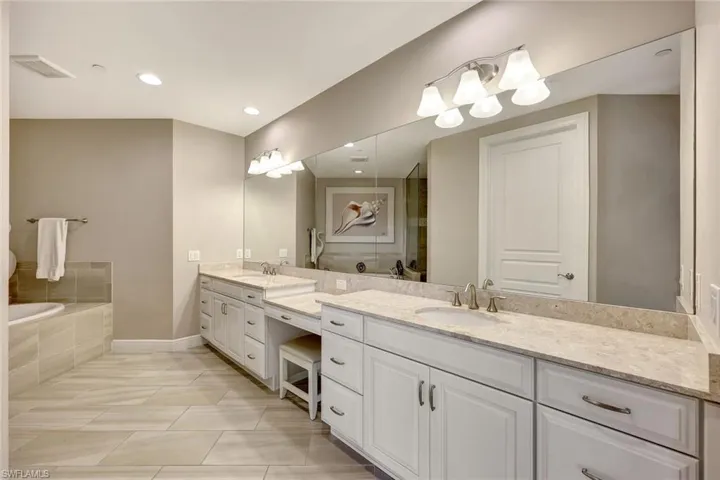 Bathroom with a washtub, vanity, and tile patterned floors
