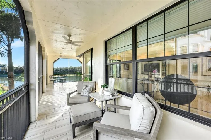 Sunroom / solarium with ceiling fan and a water view