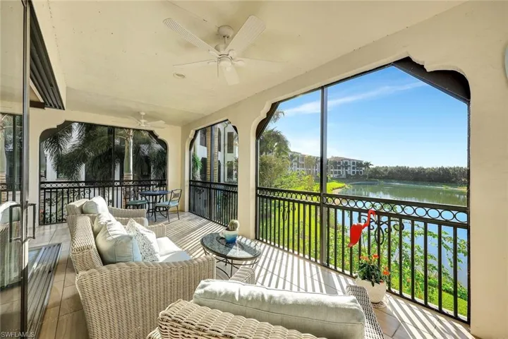 Sunroom with ceiling fan and a water view