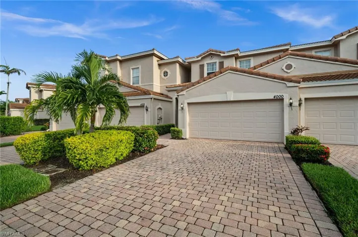 Stucco exterior with a tiled roof and integrated garage doors
