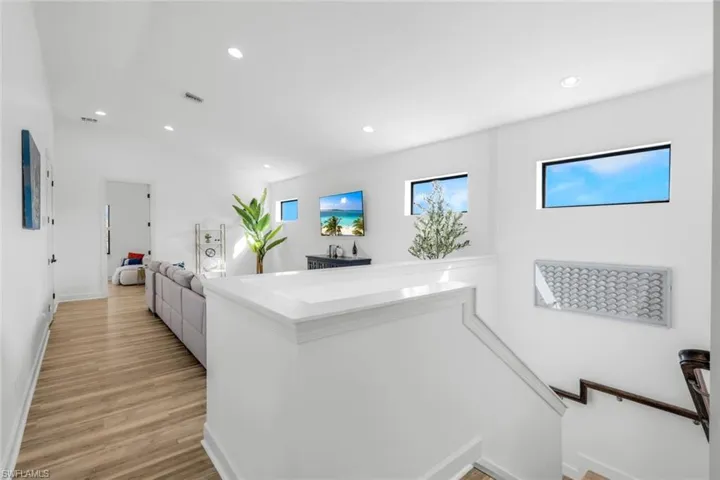 Corridor with lofted ceiling and light hardwood / wood-style floors