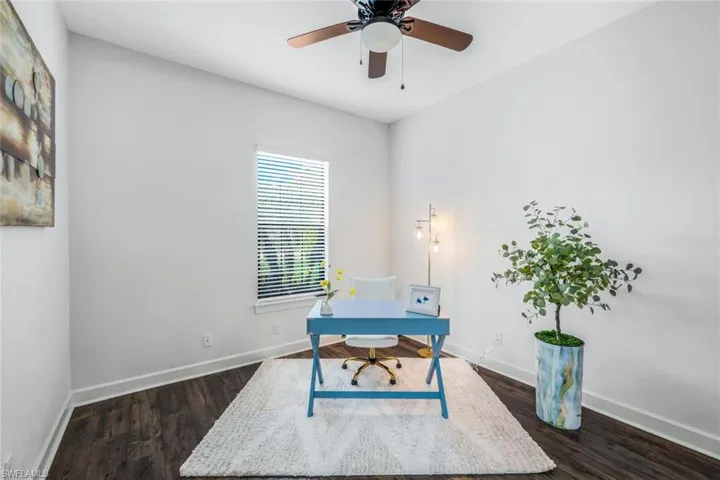 Home office featuring dark hardwood / wood-style flooring and ceiling fan