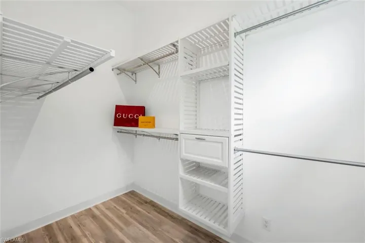 Spacious closet featuring hardwood / wood-style flooring