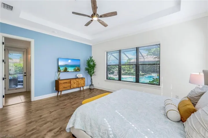 MASTER Bedroom featuring hardwood / wood-style flooring, multiple windows, and a tray ceiling