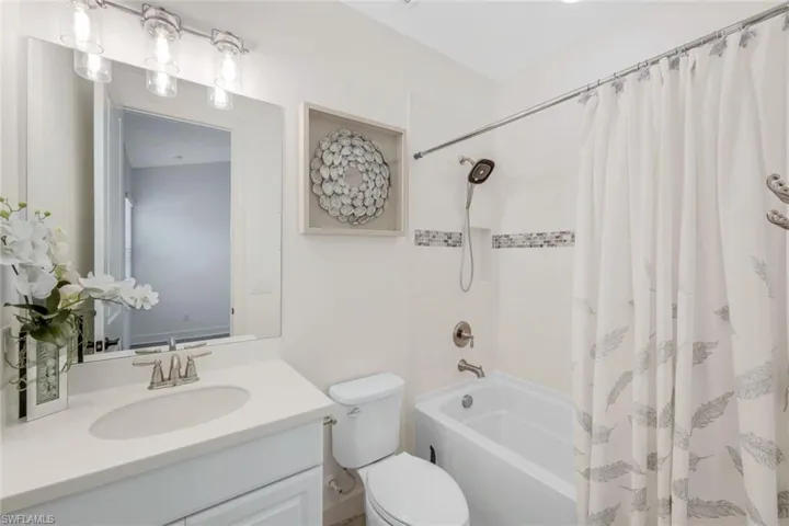 Full bathroom featuring vanity, shower / bath combo, and toilet